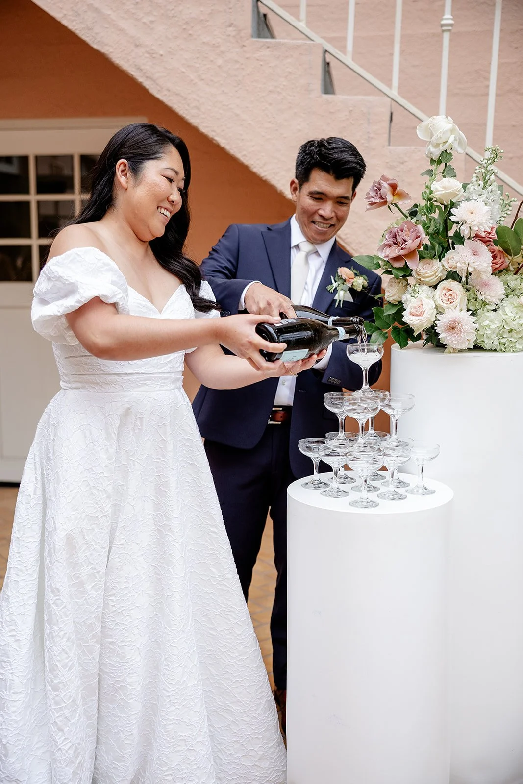 bride and groom puring champagne tower