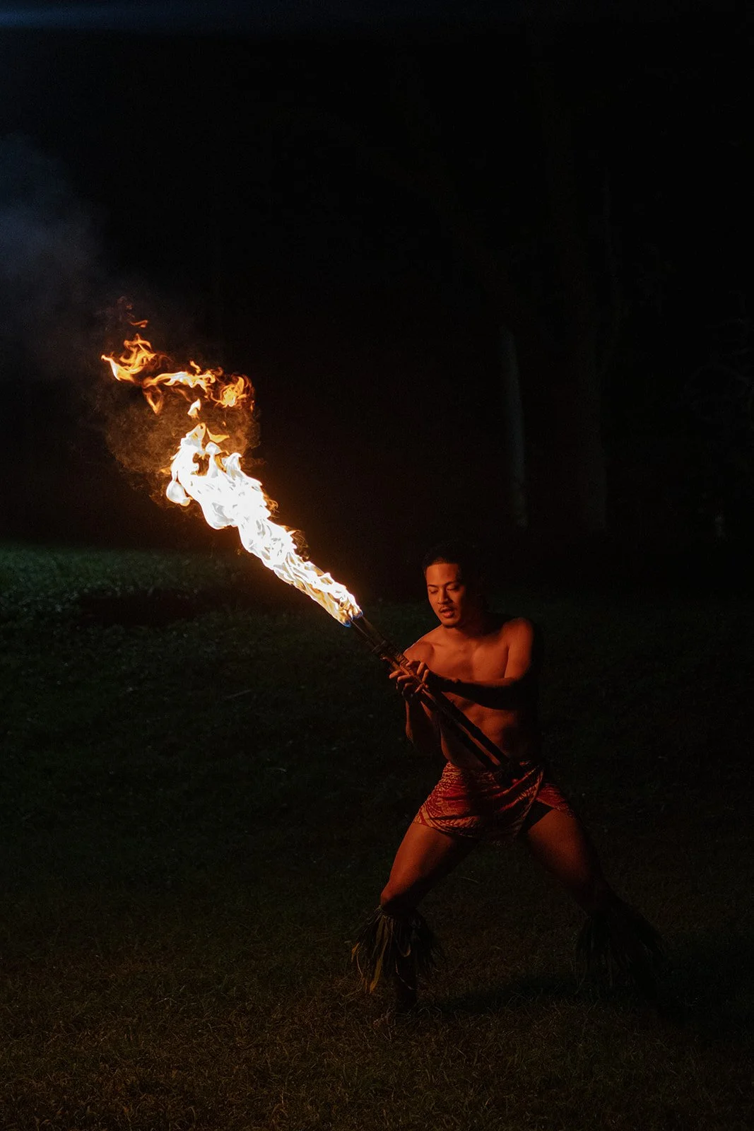 Close up of fire knife performer at this Paliku Gardens wedding, planned by Hawaii wedding planner Love Letter Weddings