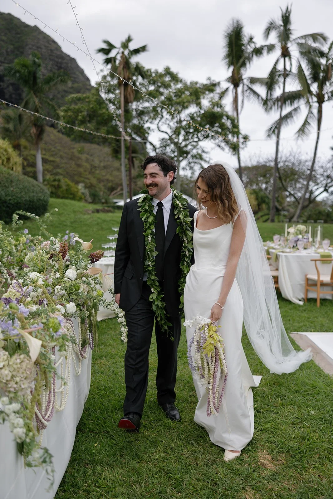 Bride and groom admire their reception, styled by Oahu wedding planner Love Letter Weddings at Paliku Gardens