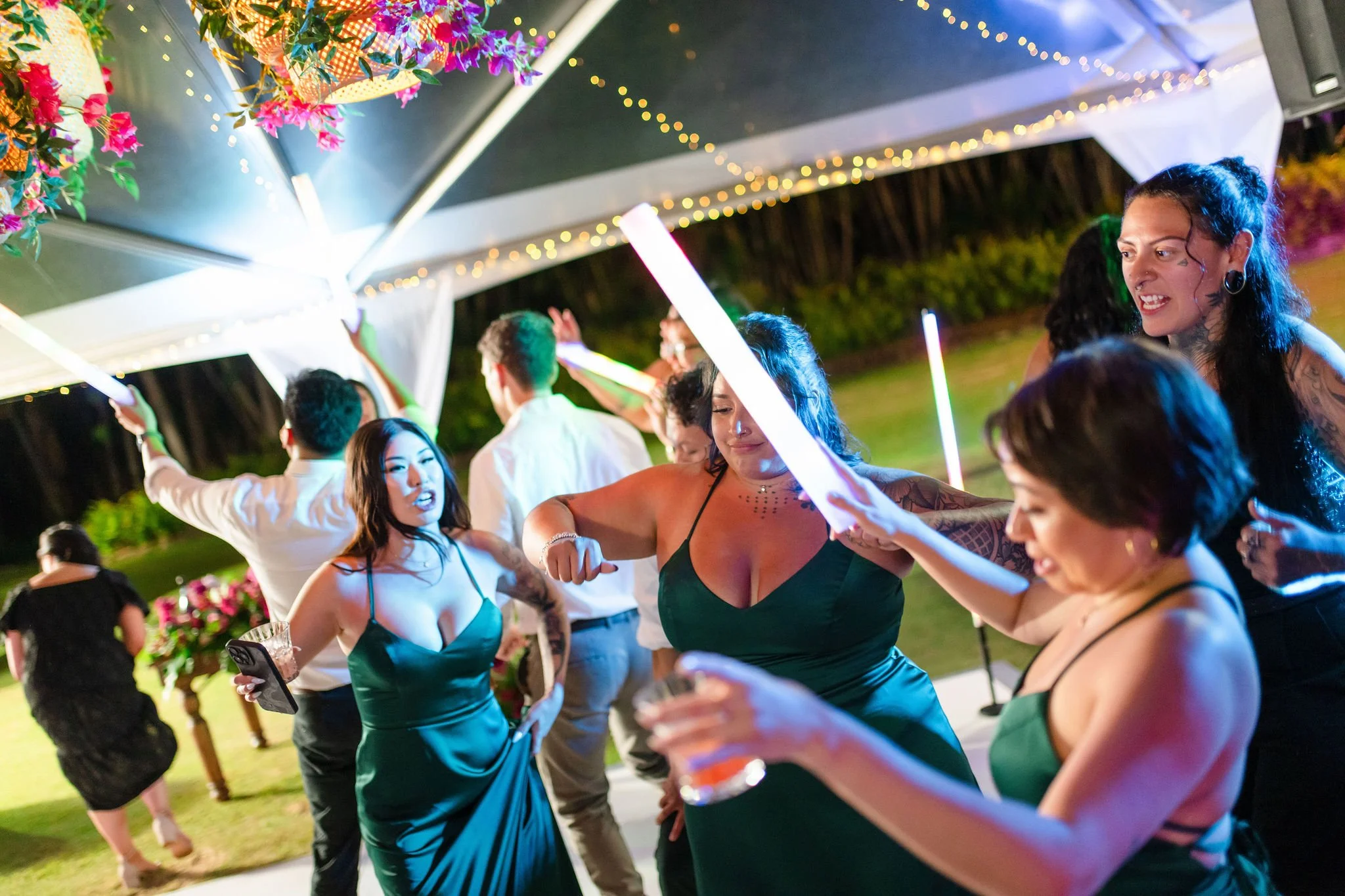 wedding guests dancing with large glow sticks