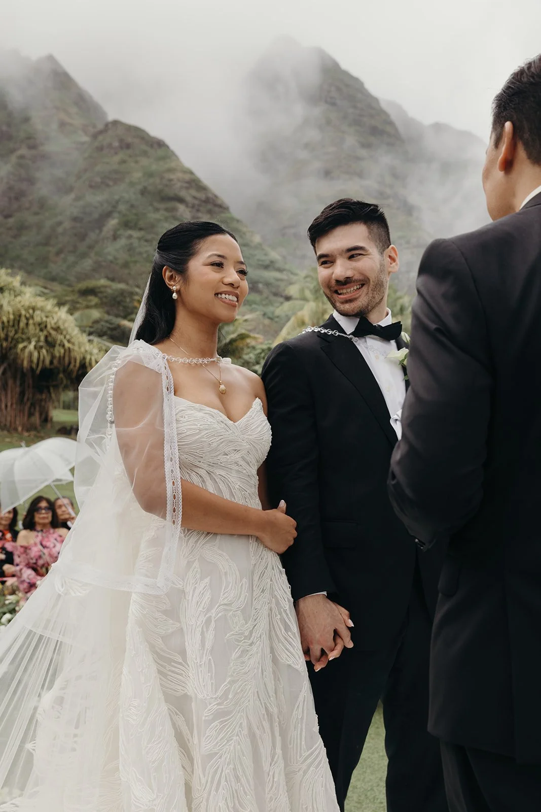 bride and groom in front of mountains in hawaii