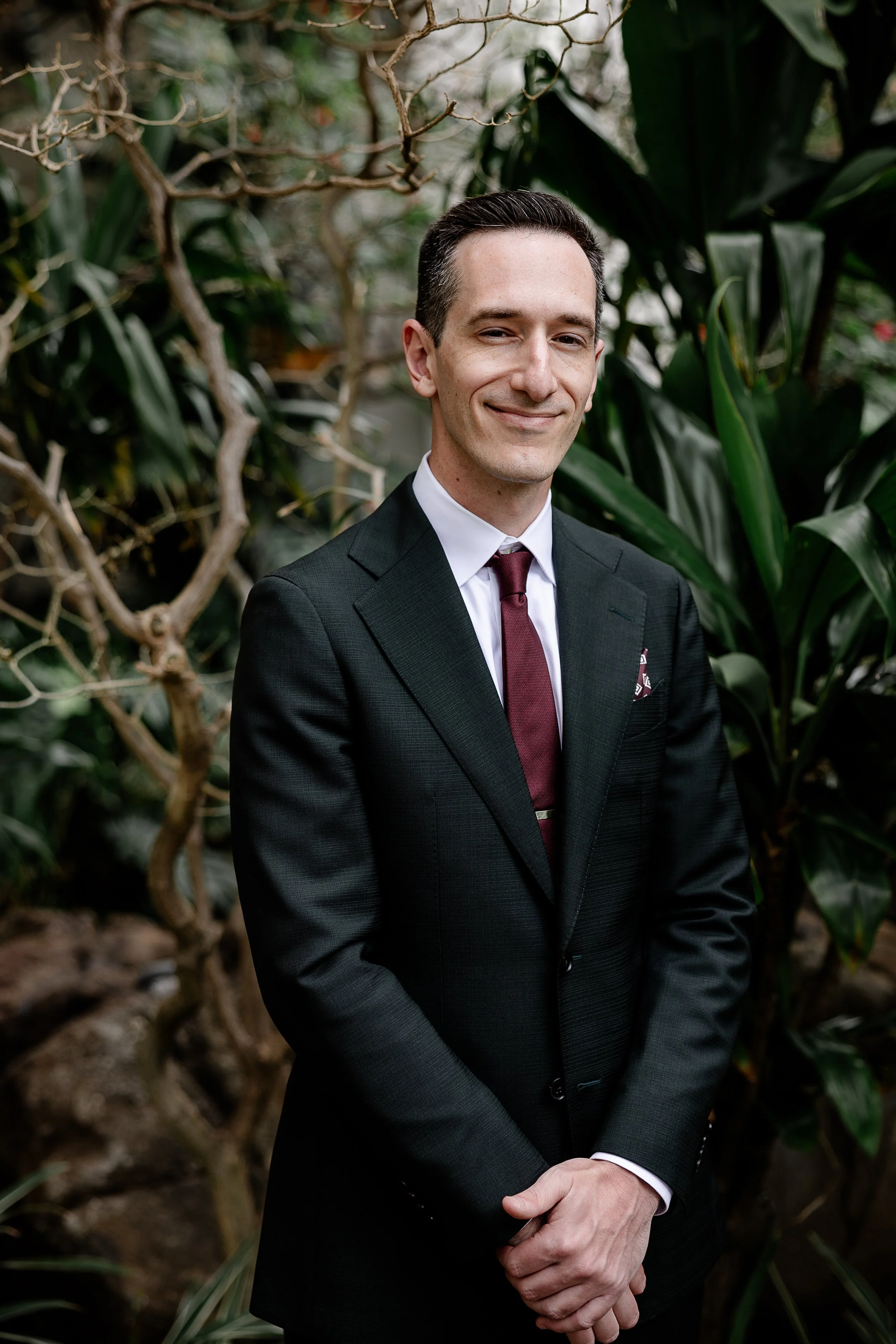 groom with maroon tie and black suit