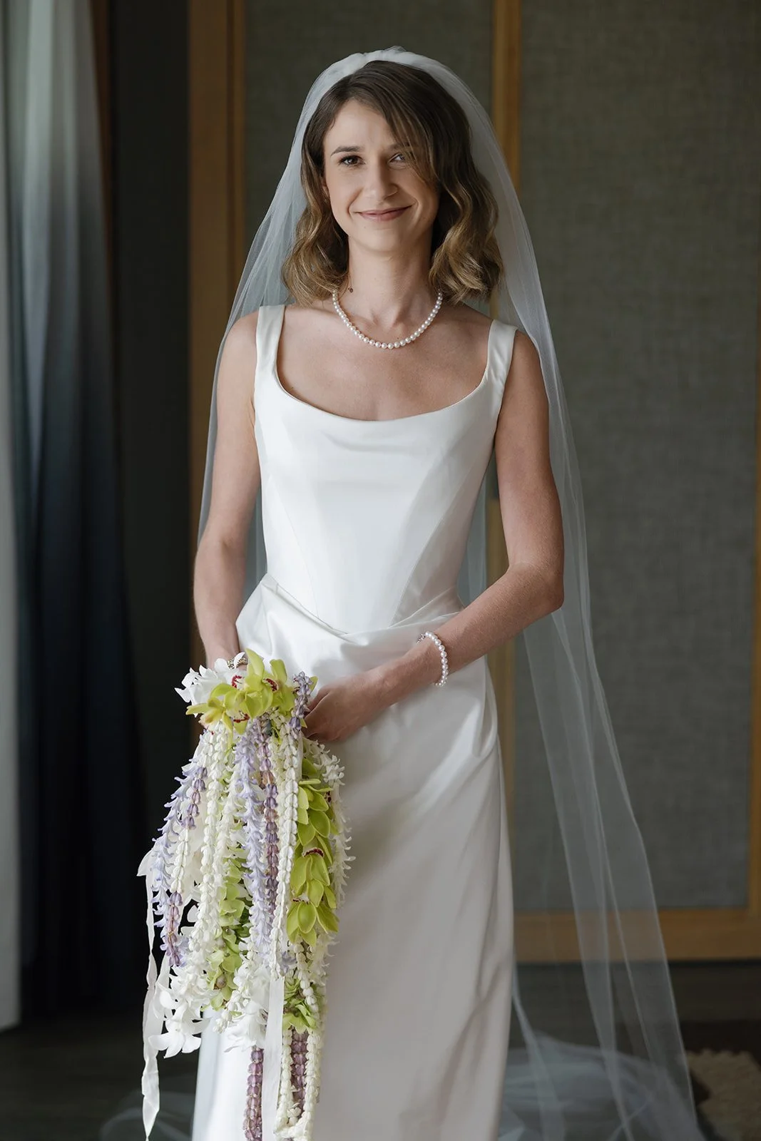 Bride in cathedral veil with pearl jewelry and cascading bouquet at Paliku Gardens wedding on Oahu