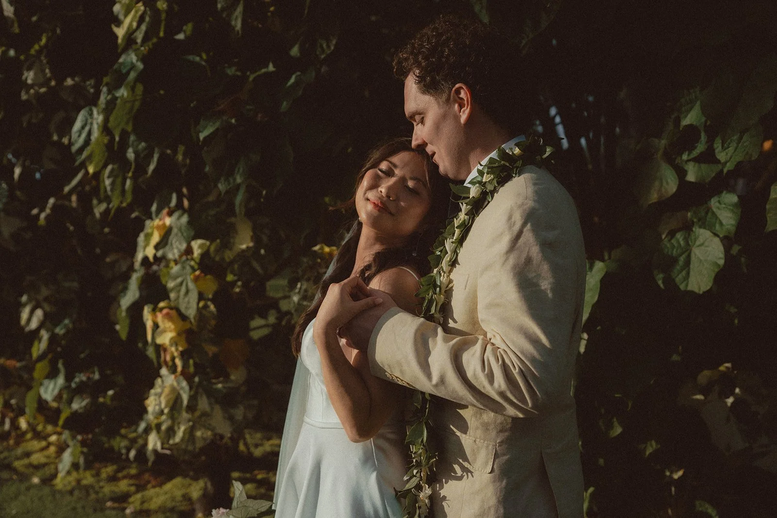 bride and groom by greenery