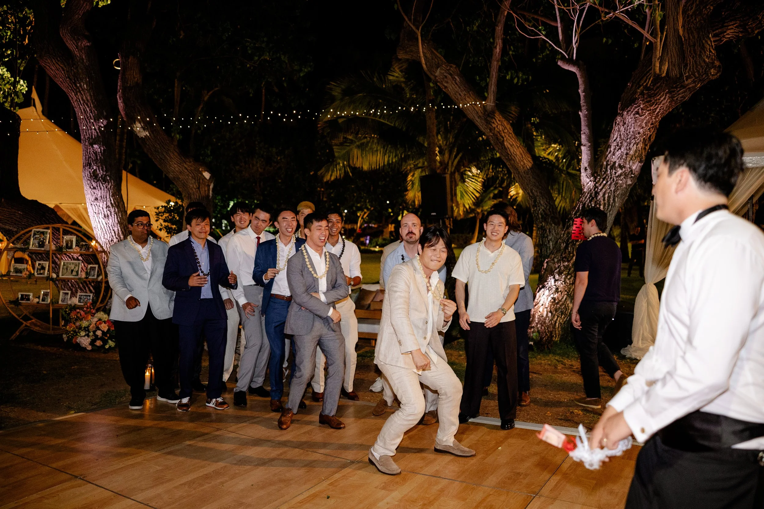 groom holding garter with male guests waiting behind him to throw garter