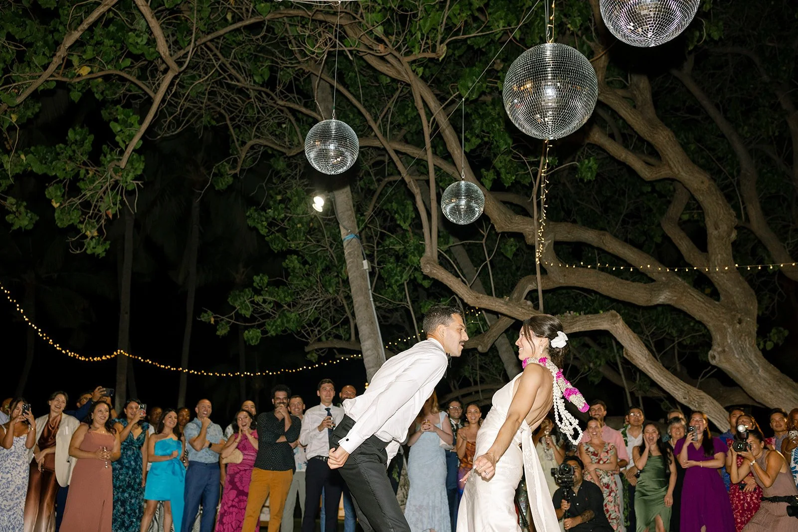 bride and groom dancing under disco balls