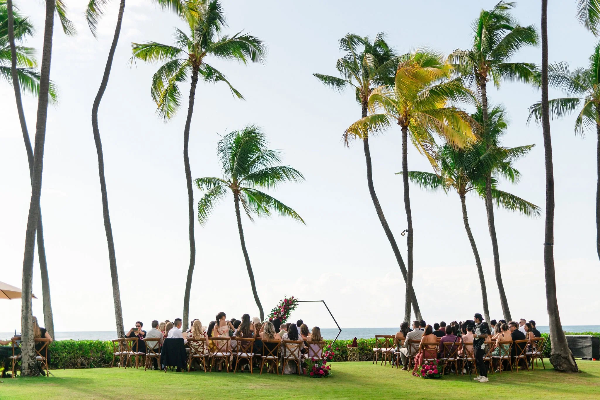 guests sitting at wedding ceremony near beach in hawaii