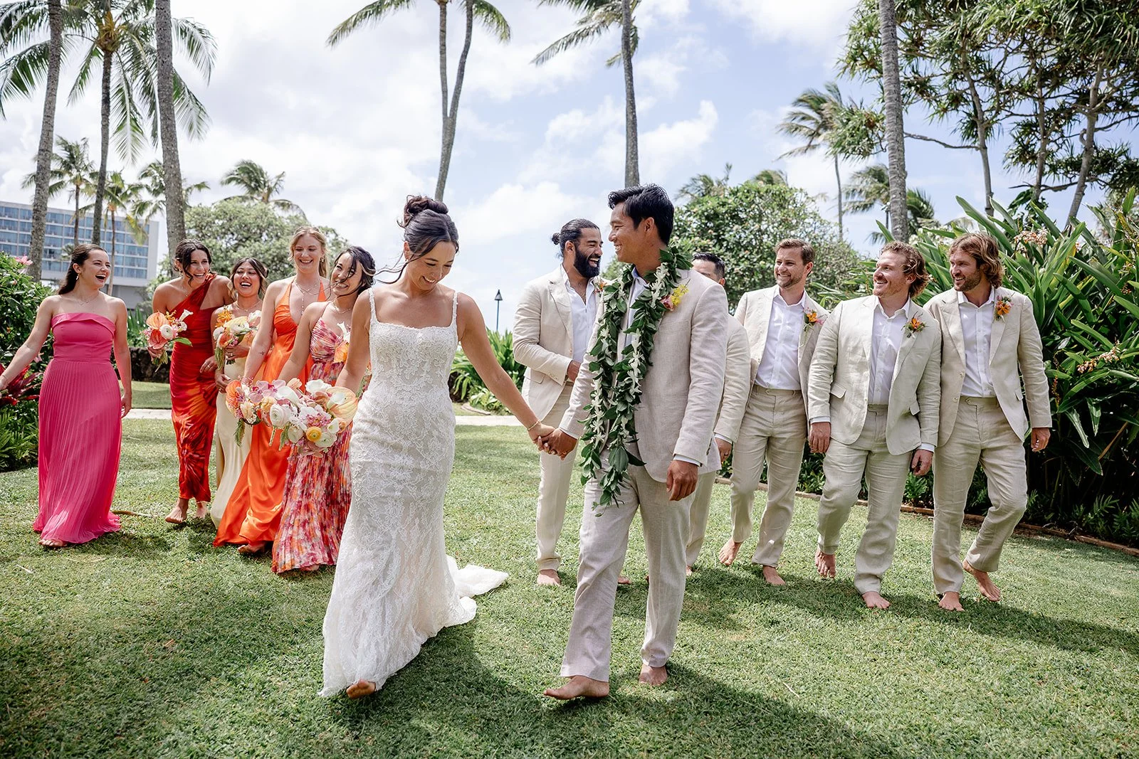 bride and groom with wedding party in Hawaii under palm trees