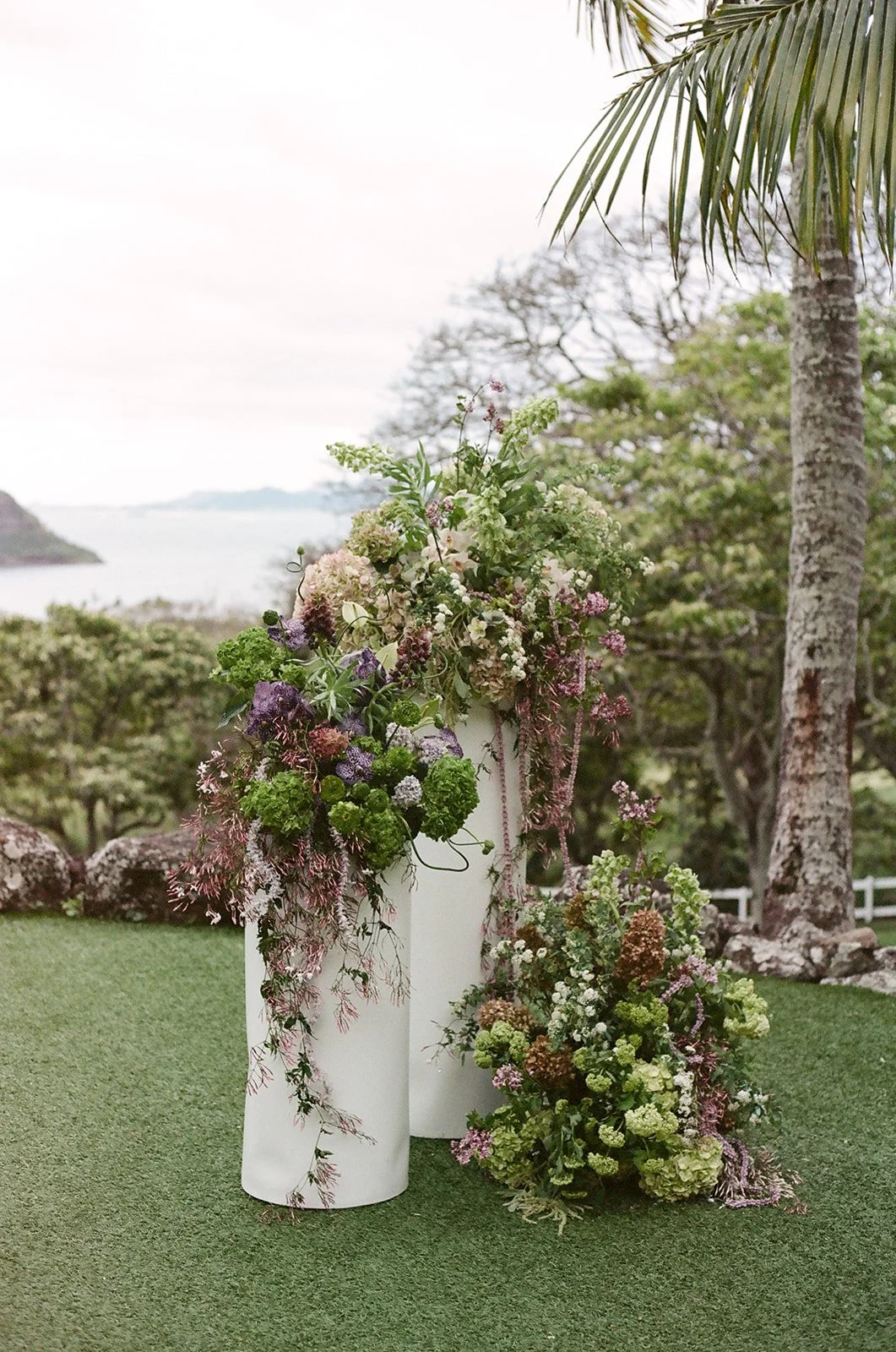 Close up of altar pillars with large flower arrangements at Paliku Gardens wedding in Hawaii