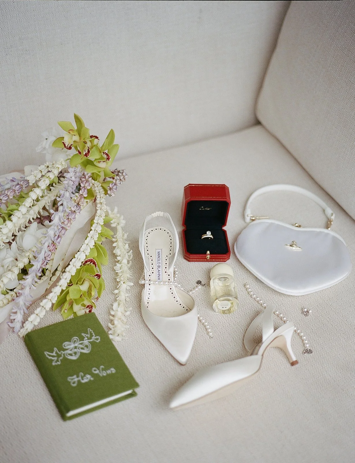 Bridal flatlay with bouquet, shoes, jewelry, and vow book at Paliku Gardens wedding in Hawaii