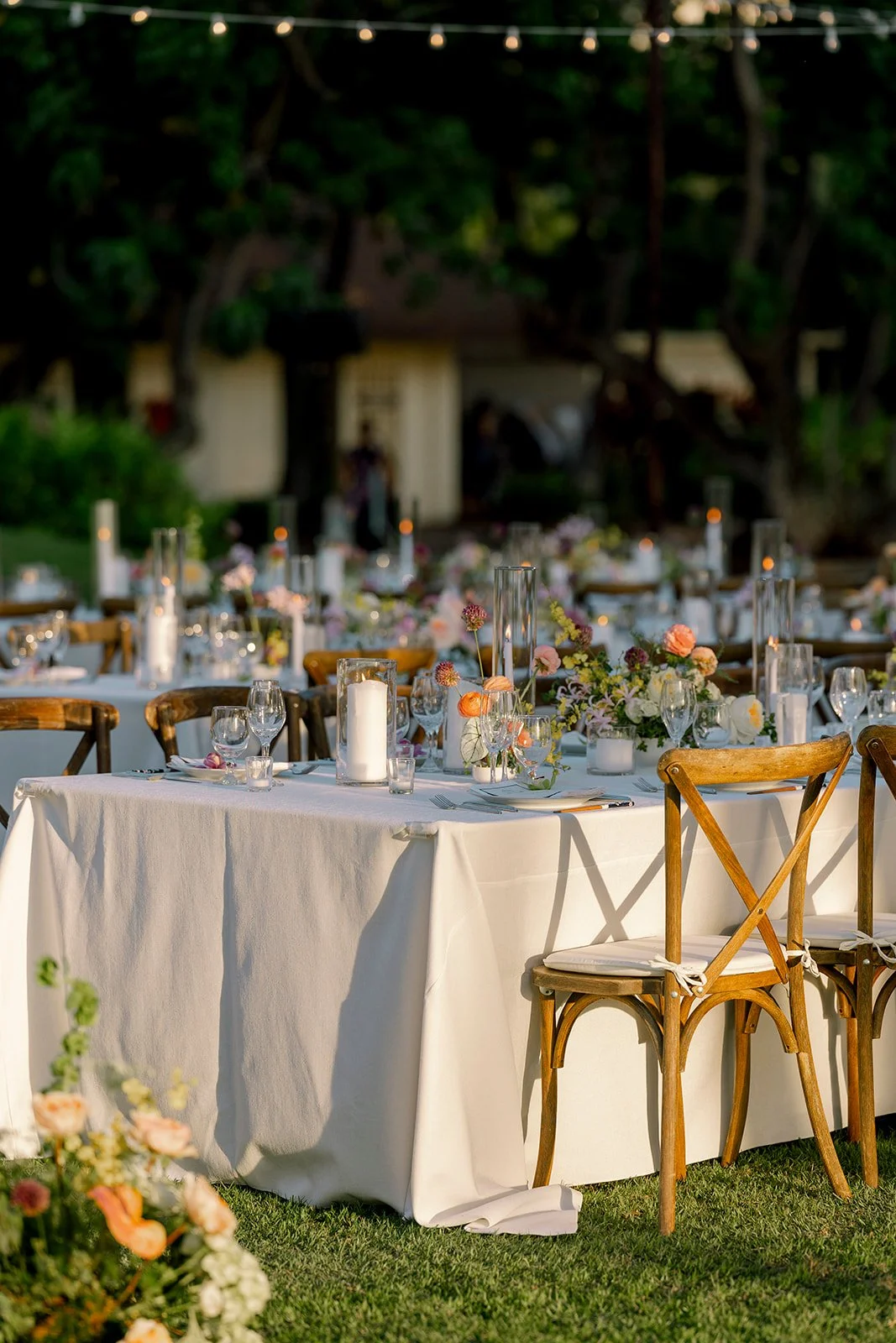 wedding reception with candles, pastel florals, and white linens