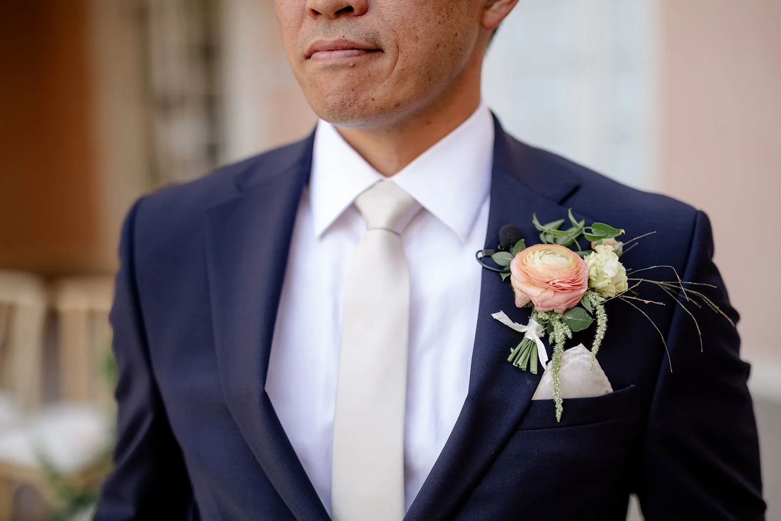 groom in navy suit with mauve boutonniere