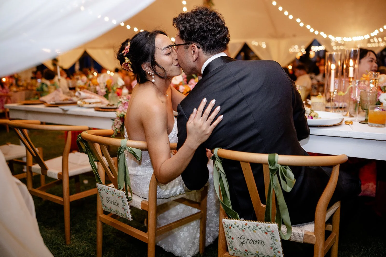 bride and groom kissing at dinner table