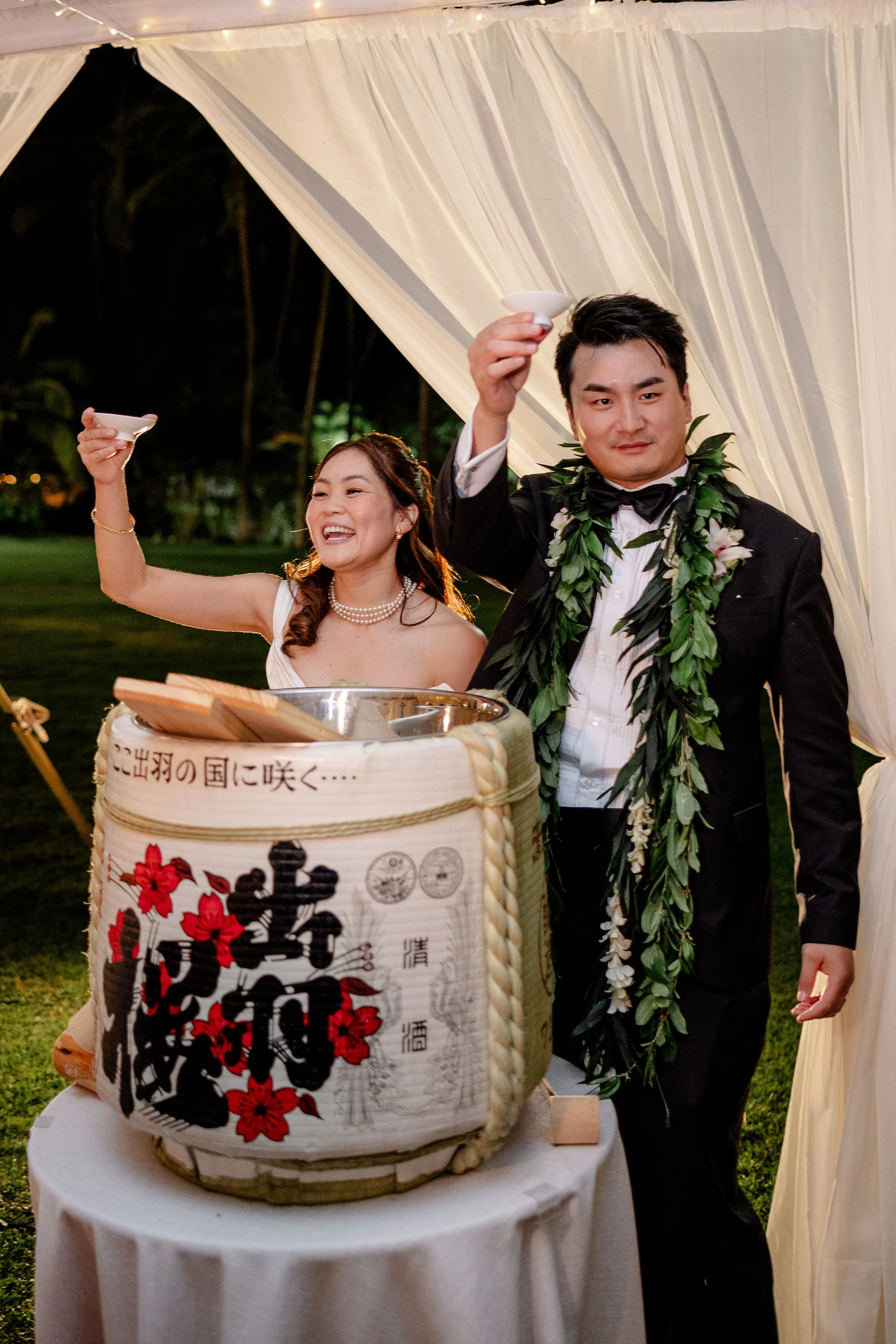 bride and groom open sake barrel and cheers to guests with sake cups