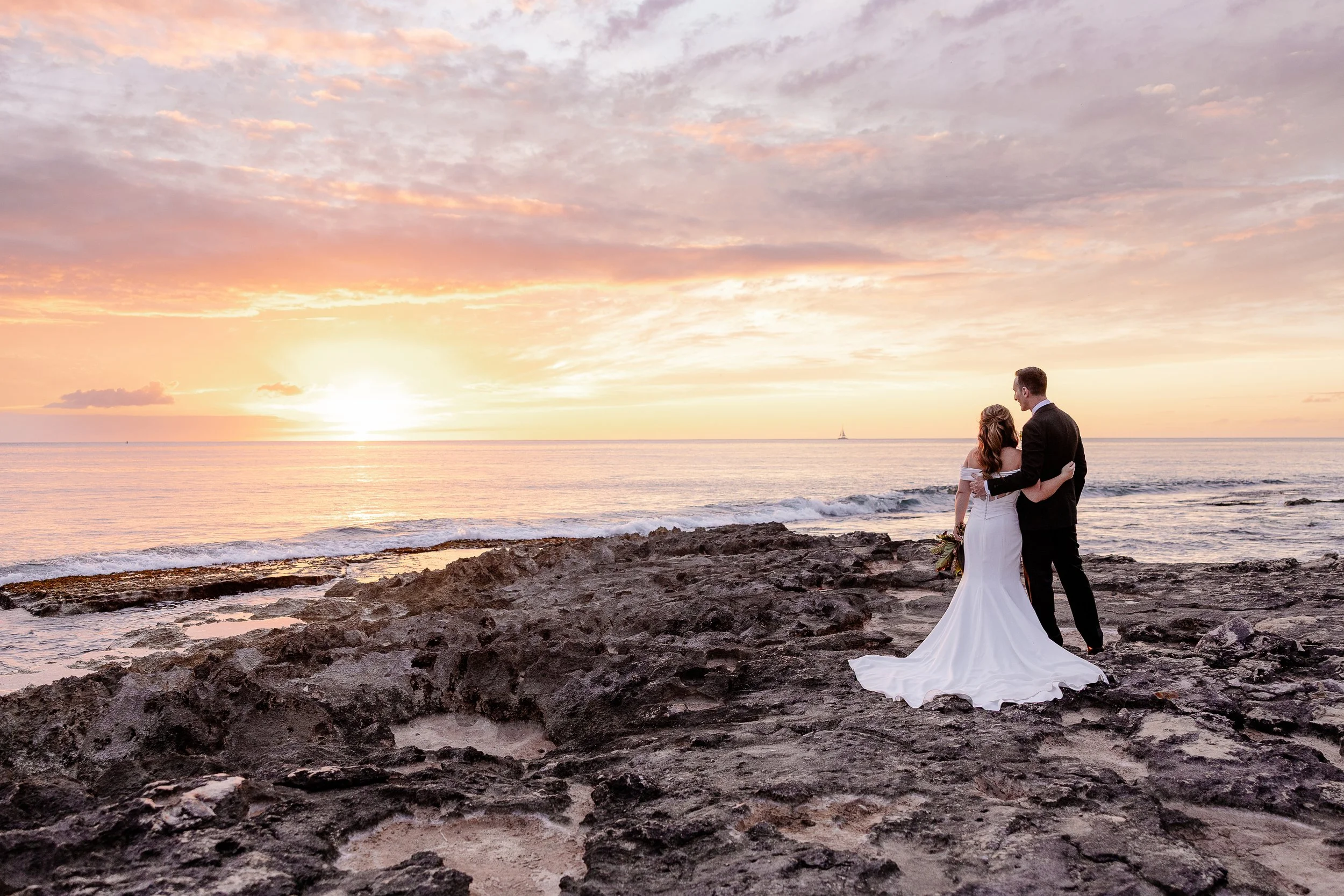 bride and groom on a beach in Hawai'i at sunset