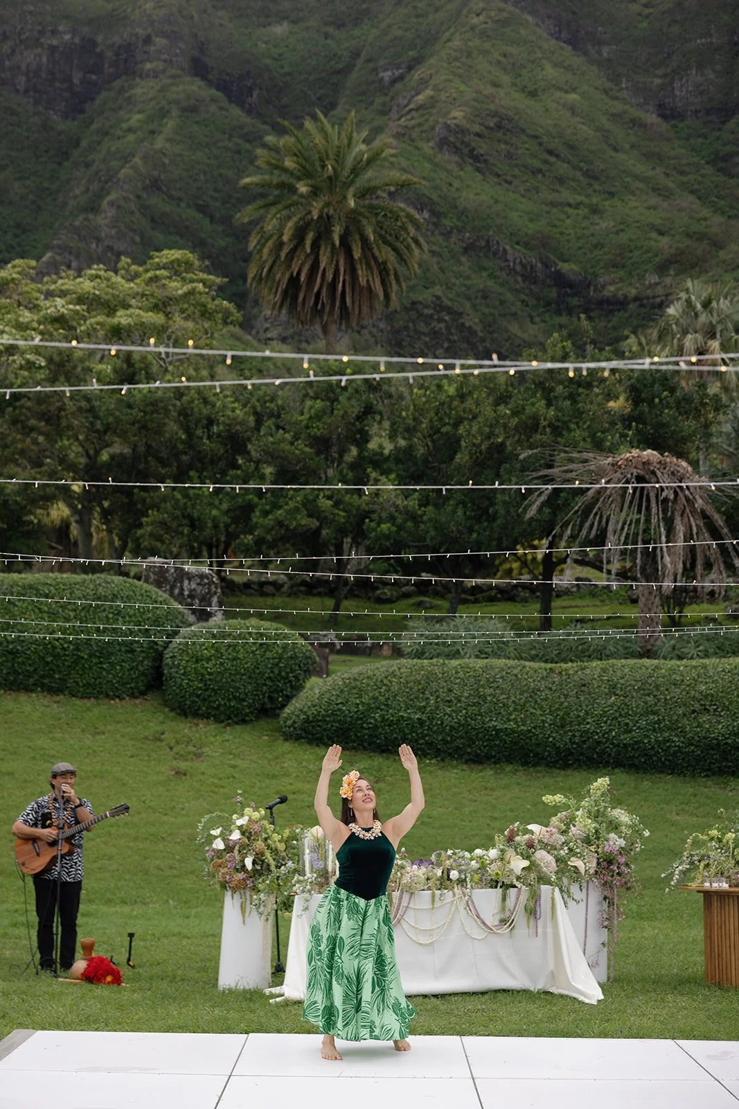 Hula dancer performs on the dance floor in front of the sweetheart table at this Paliku Gardens wedding, planned by Oahu wedding planner Love Letter Weddings