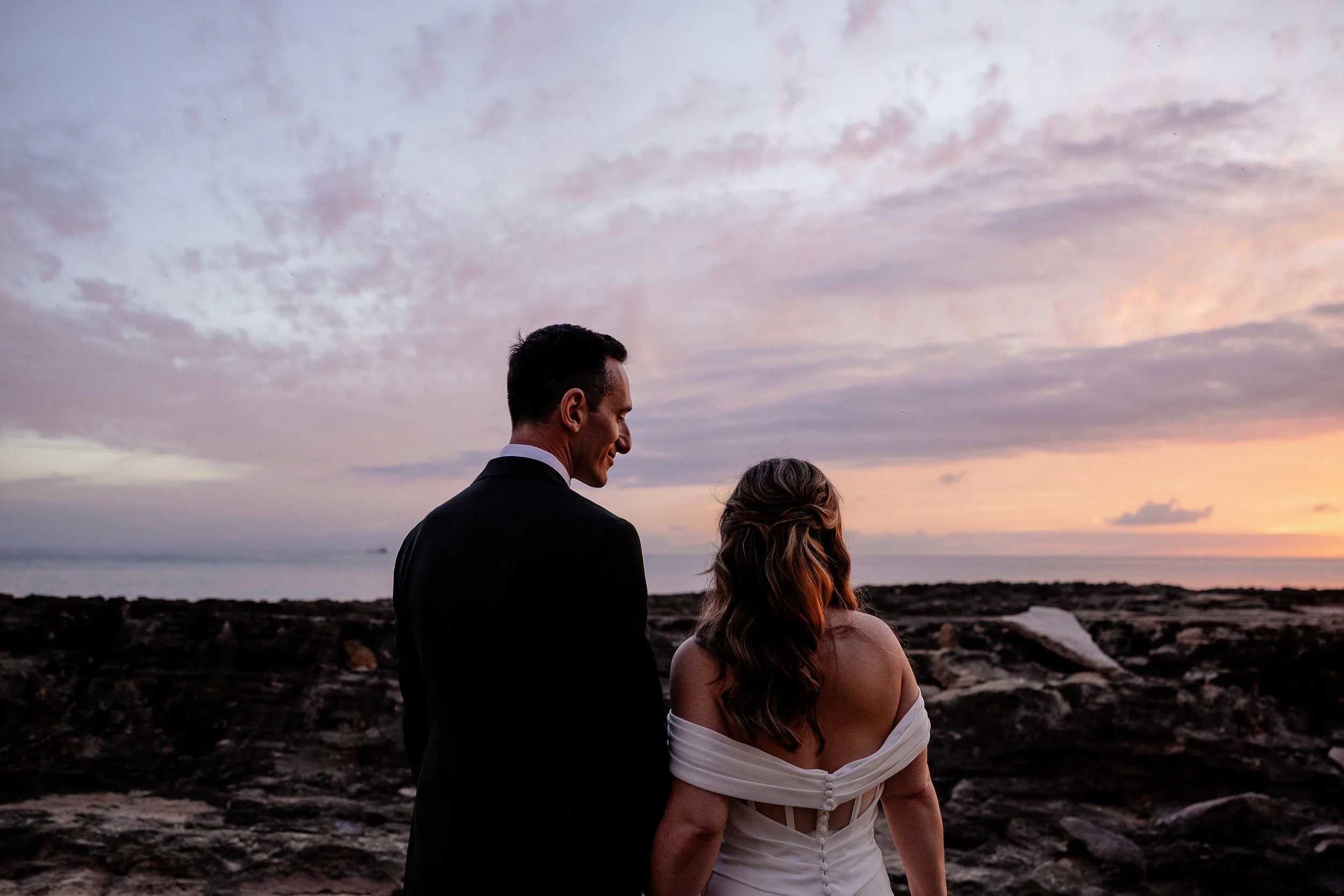 Bride and Groom on a beach in Hawai'i watching sunset