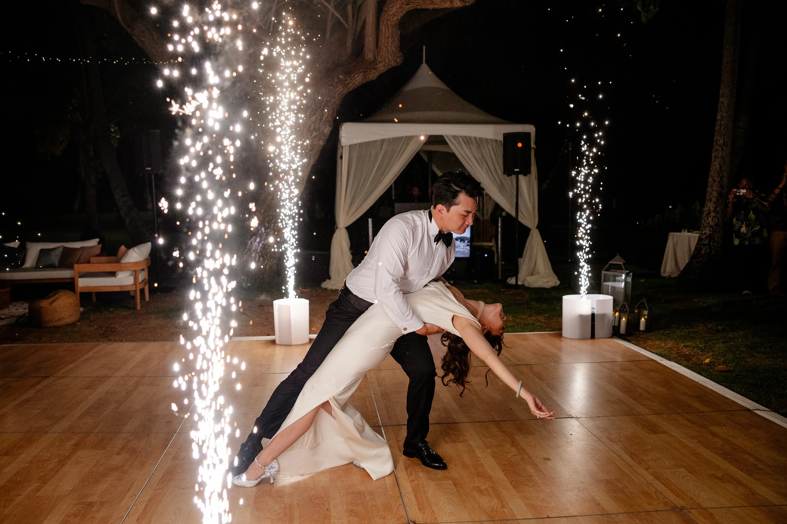 bride and groom first dance together with machine fireworks around corners of the dance floor