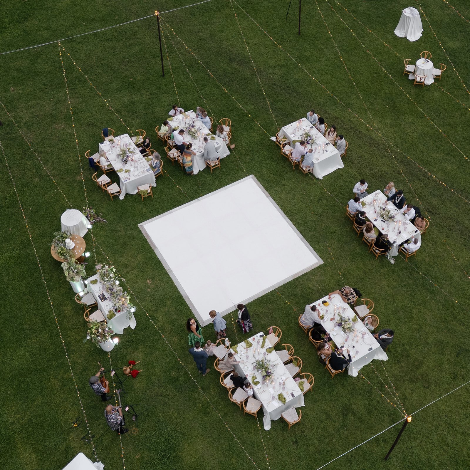 Aerial view of Hawaii wedding reception designed by Oahu wedding planner Love Letter Weddings, guests seated under twinkle lights at Paliku Gardens