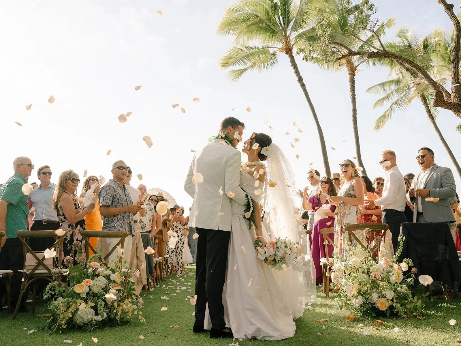 bride and groom with petals in the air after ceremony