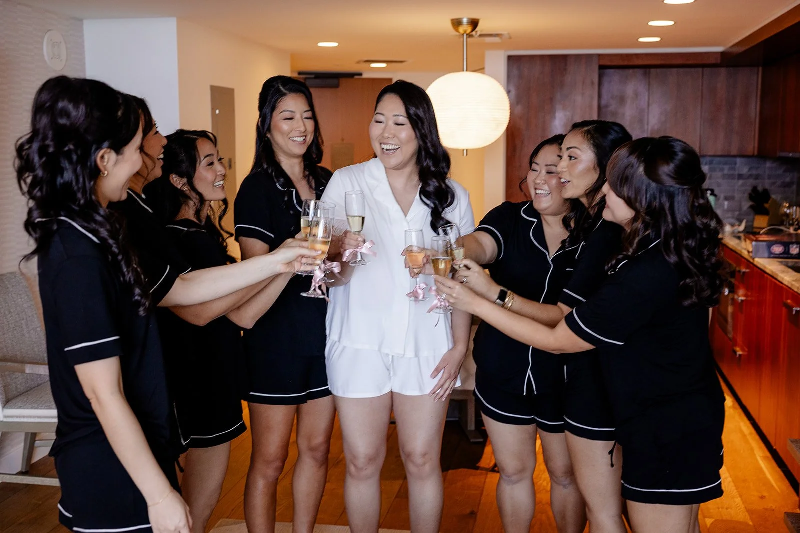 bride drinking champagne with bridemaids