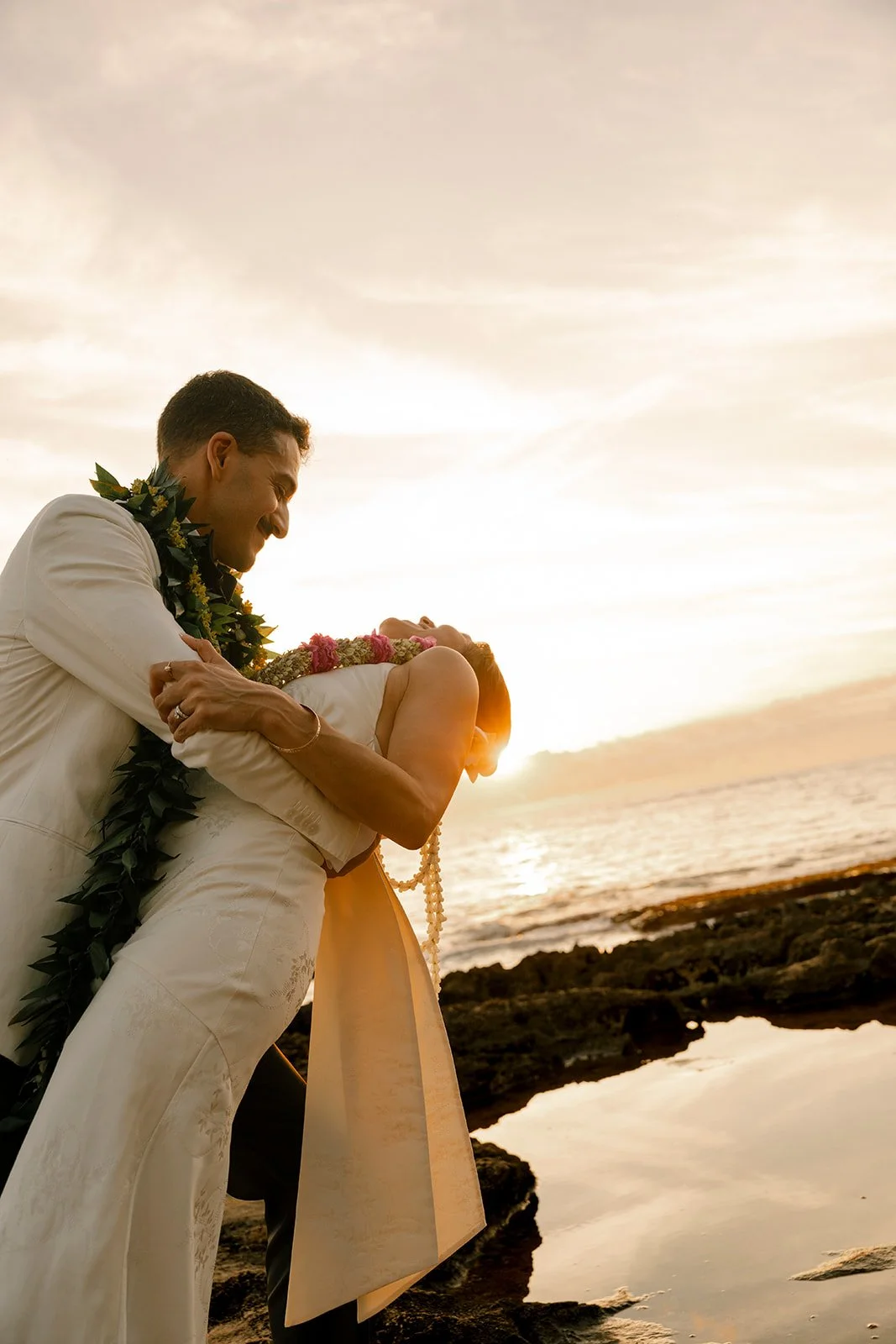 groom dipping bride at sunset in hawaii