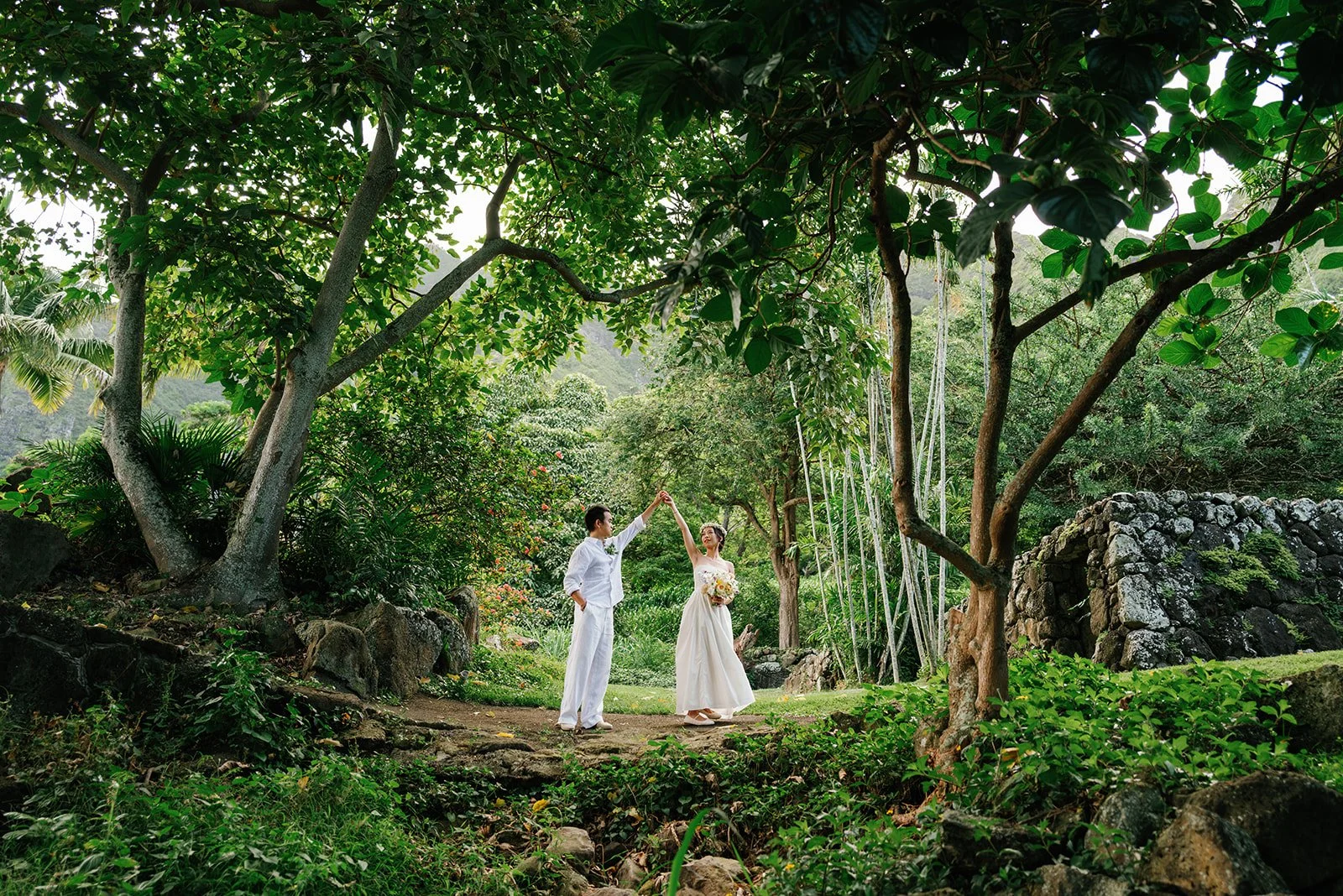 Groom spins bride captured amongst the botanical gardens