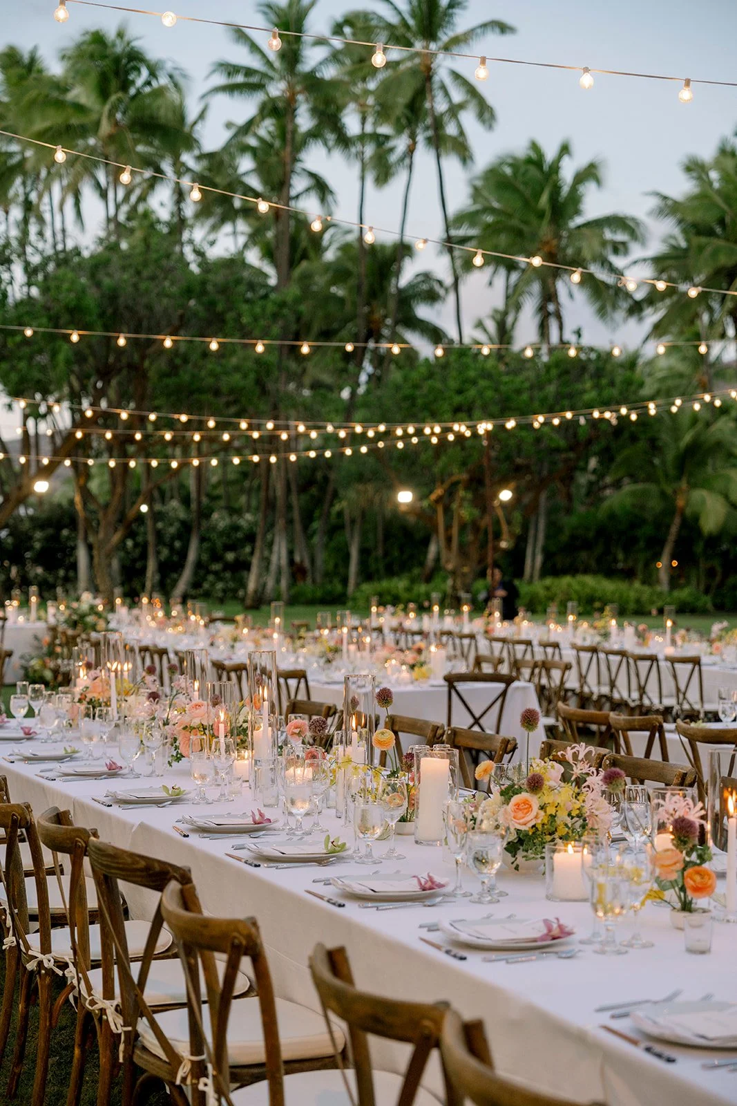 wedding reception with candles, pastel florals, and white linens