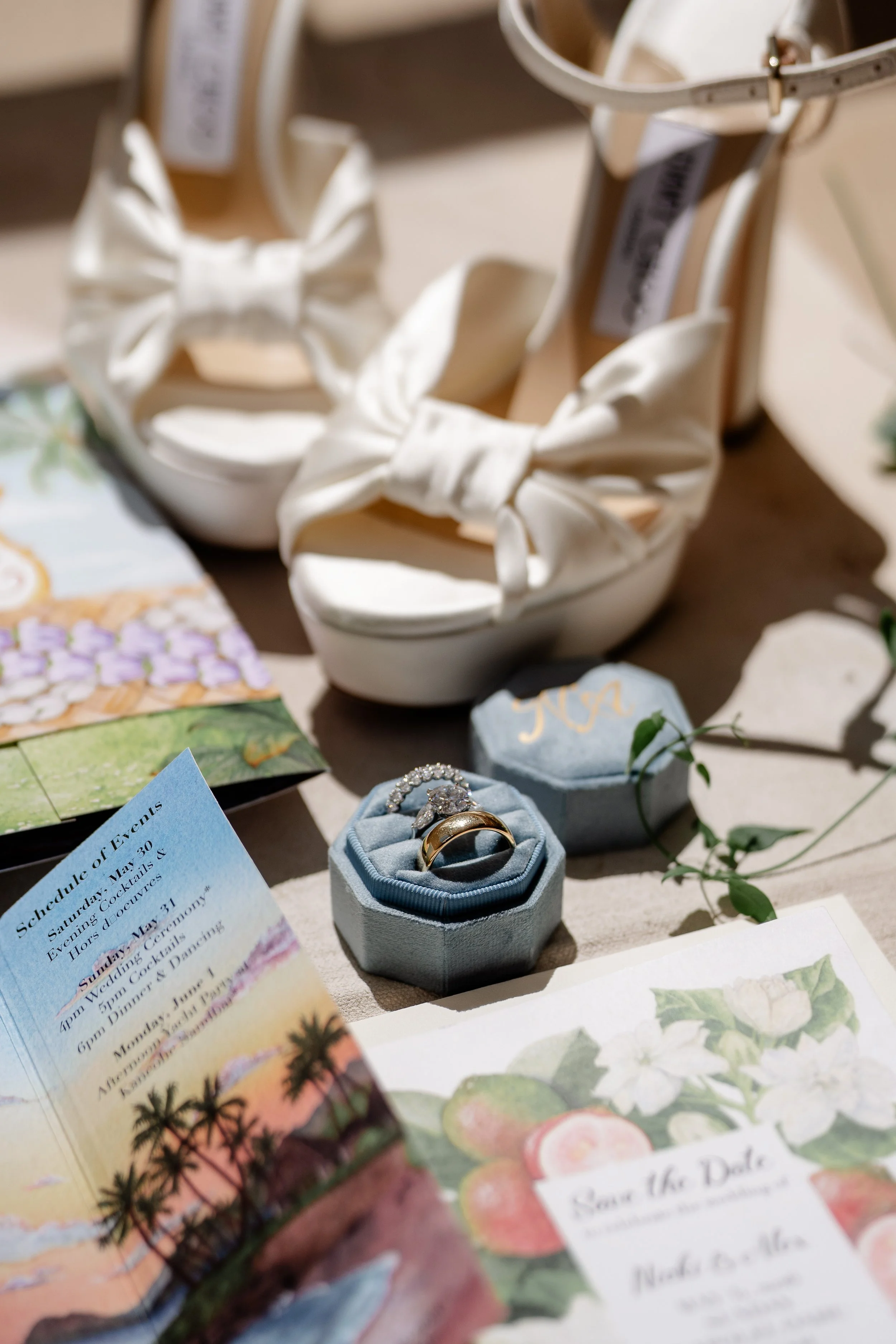 bride's wedding shoes with wedding rings and invitation cards