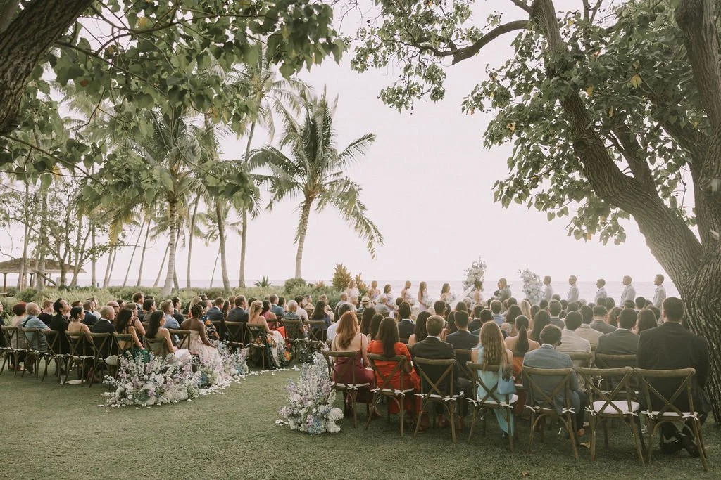 Guests sitting at the wedding ceremony at an ocean front Hawaii wedding venue.