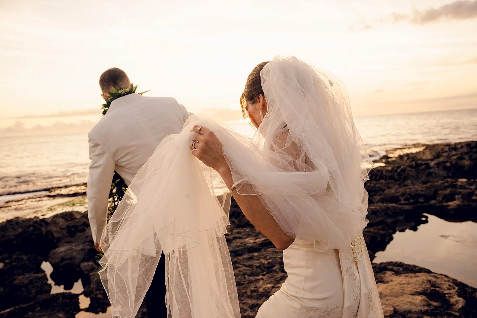 bride and groom watching sunset in hawaii