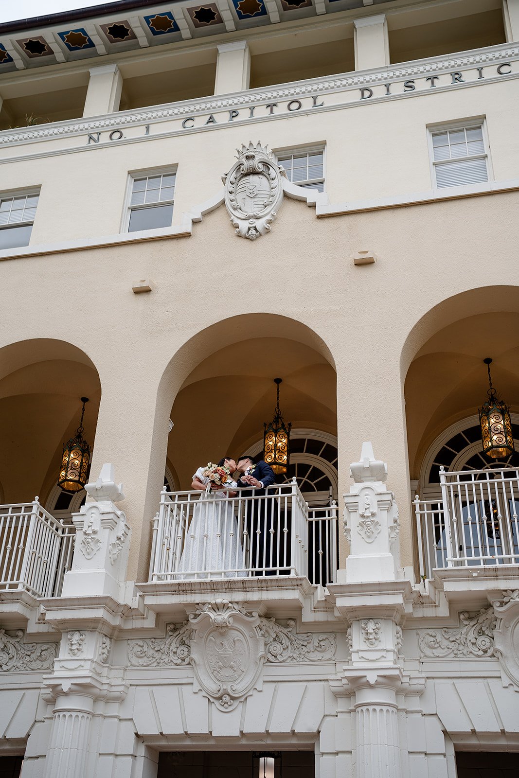 bride and groom kissing on balcony