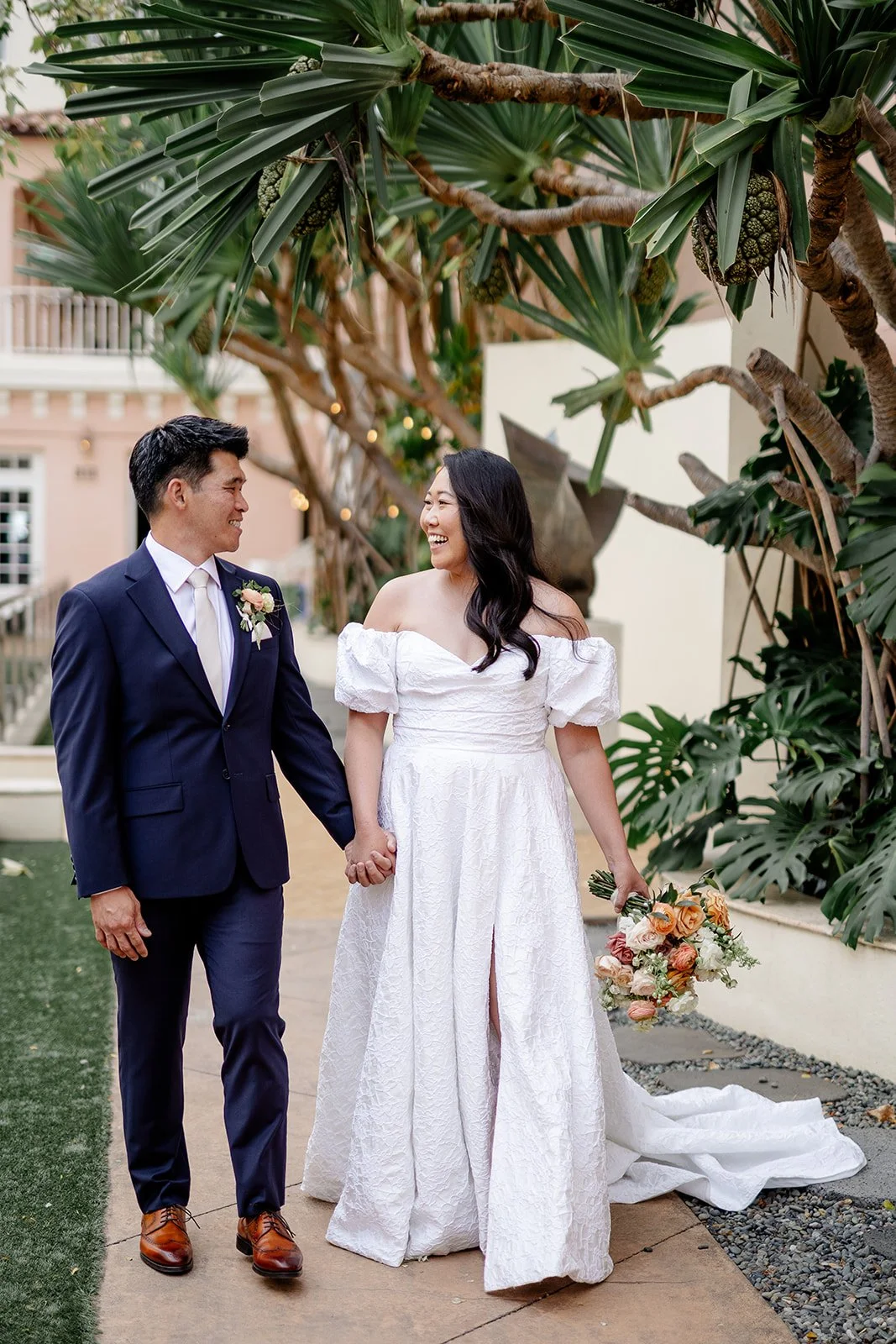 brid eand groom holding hands at capitol modern museum in hawaii