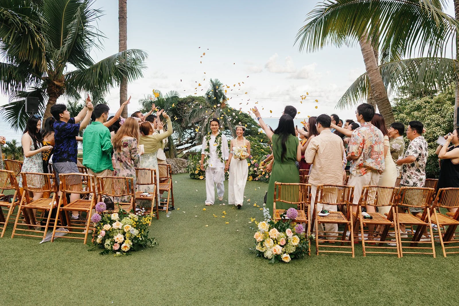 Bride and groom head down the aisle while guests toss the toss petals towards the couple
