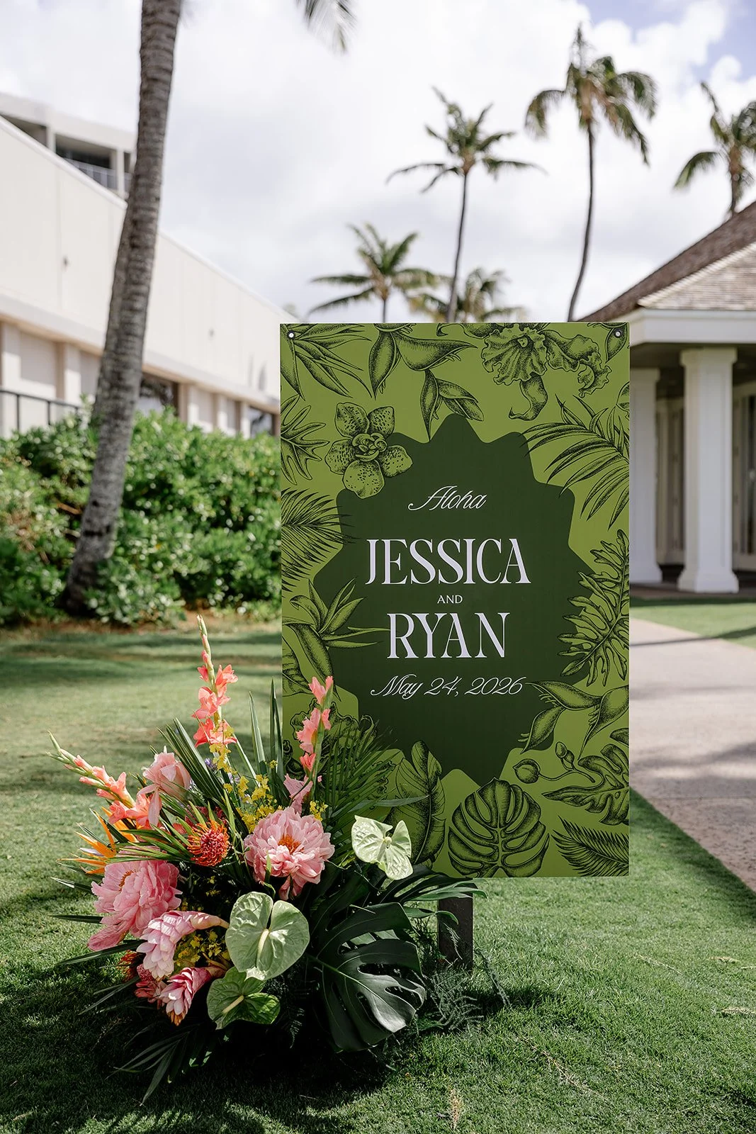 green welcome sign with tropical floral arrangment