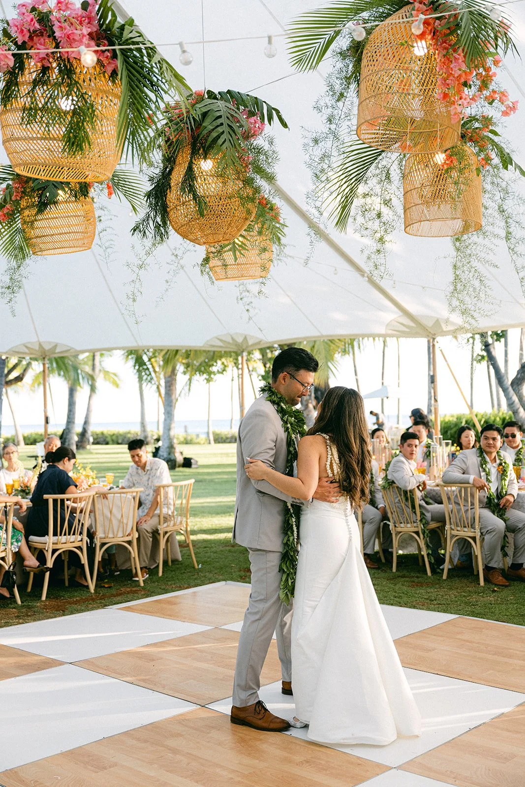 bride and groom dance under rattan lanterns