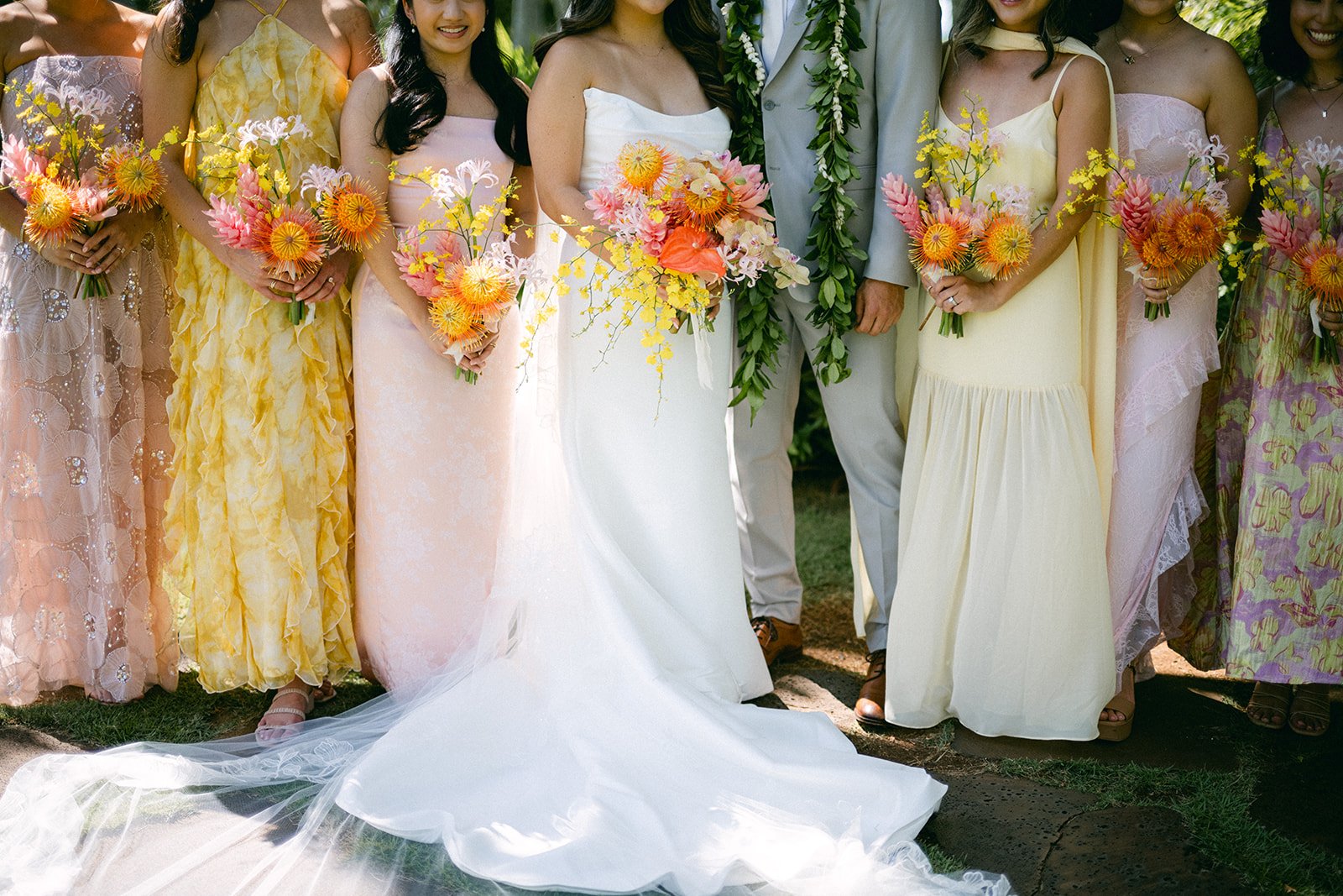 bride and bridesmaids with pink, orange, and yellow bouquets