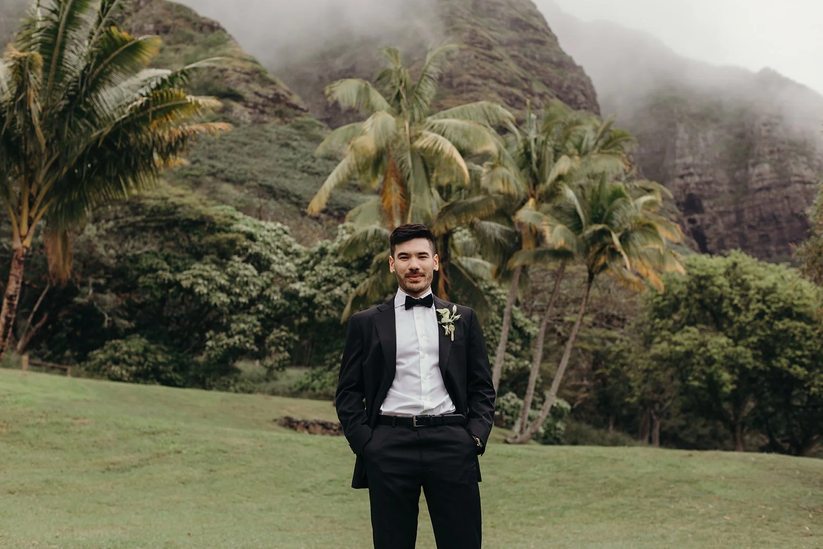 groom in front of mountains in hawaii