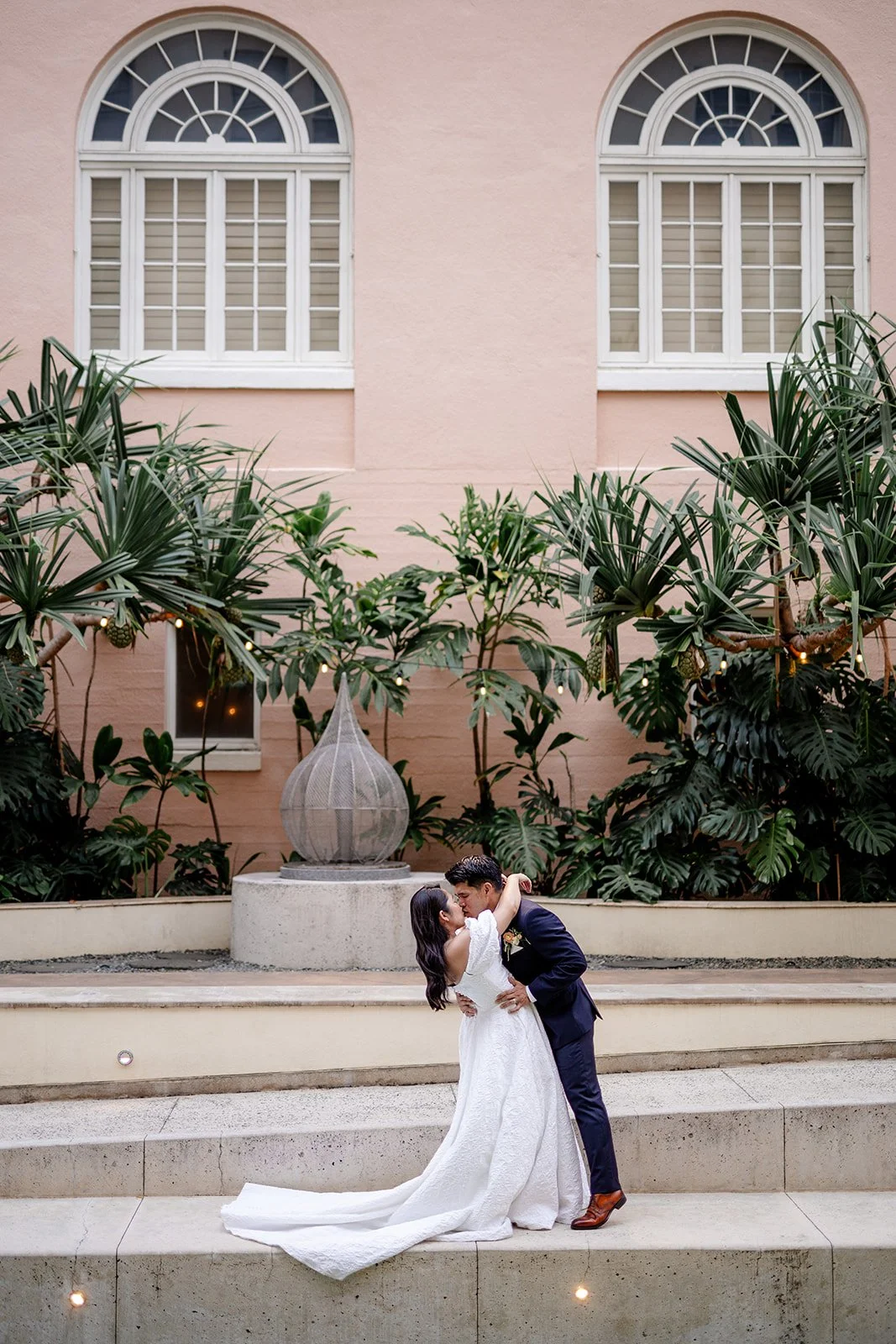 bride and groom kissing in capitol modern museum in hawaii