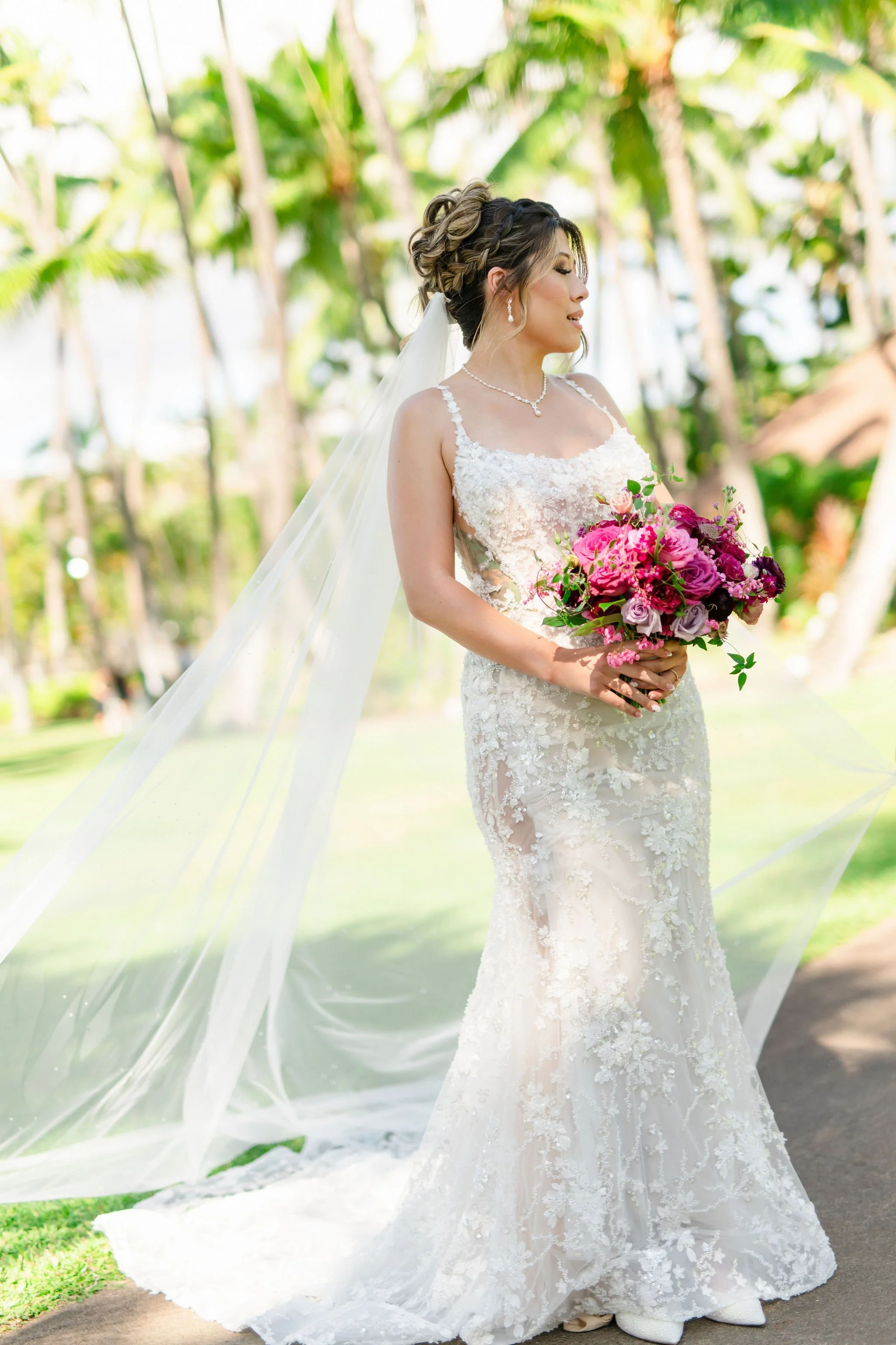 bride under palm trees at wedding in hawaii