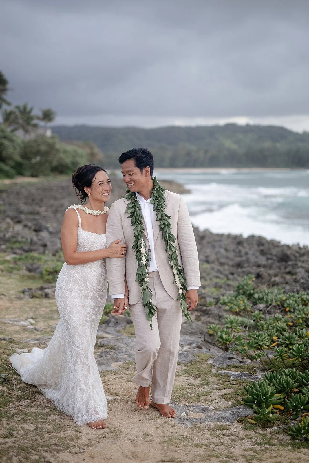 bride and groom holding hands on a beach in hawaii