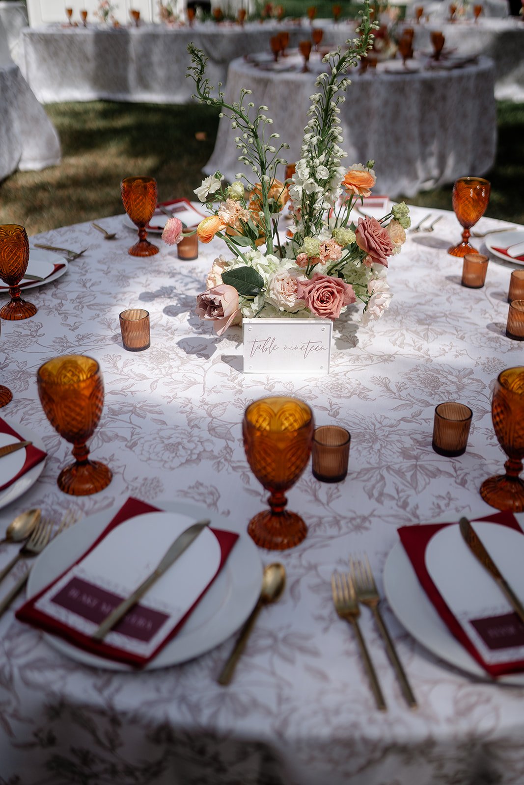 wedding table with red napkins and amber glasses