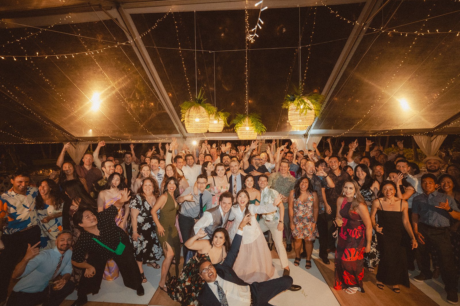 wedding guests under tent with string lights