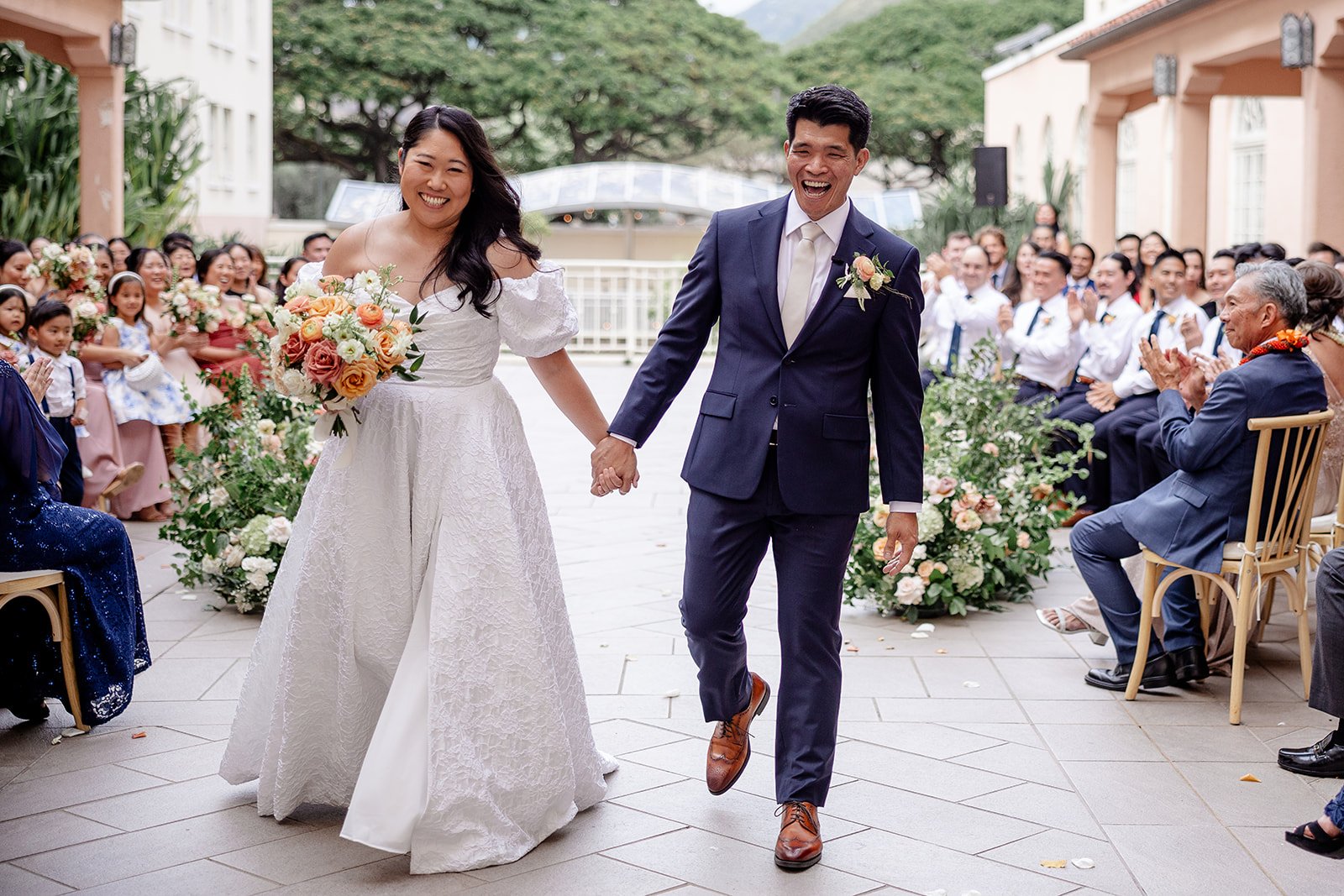 bride and groom holding hands walking down the aisle