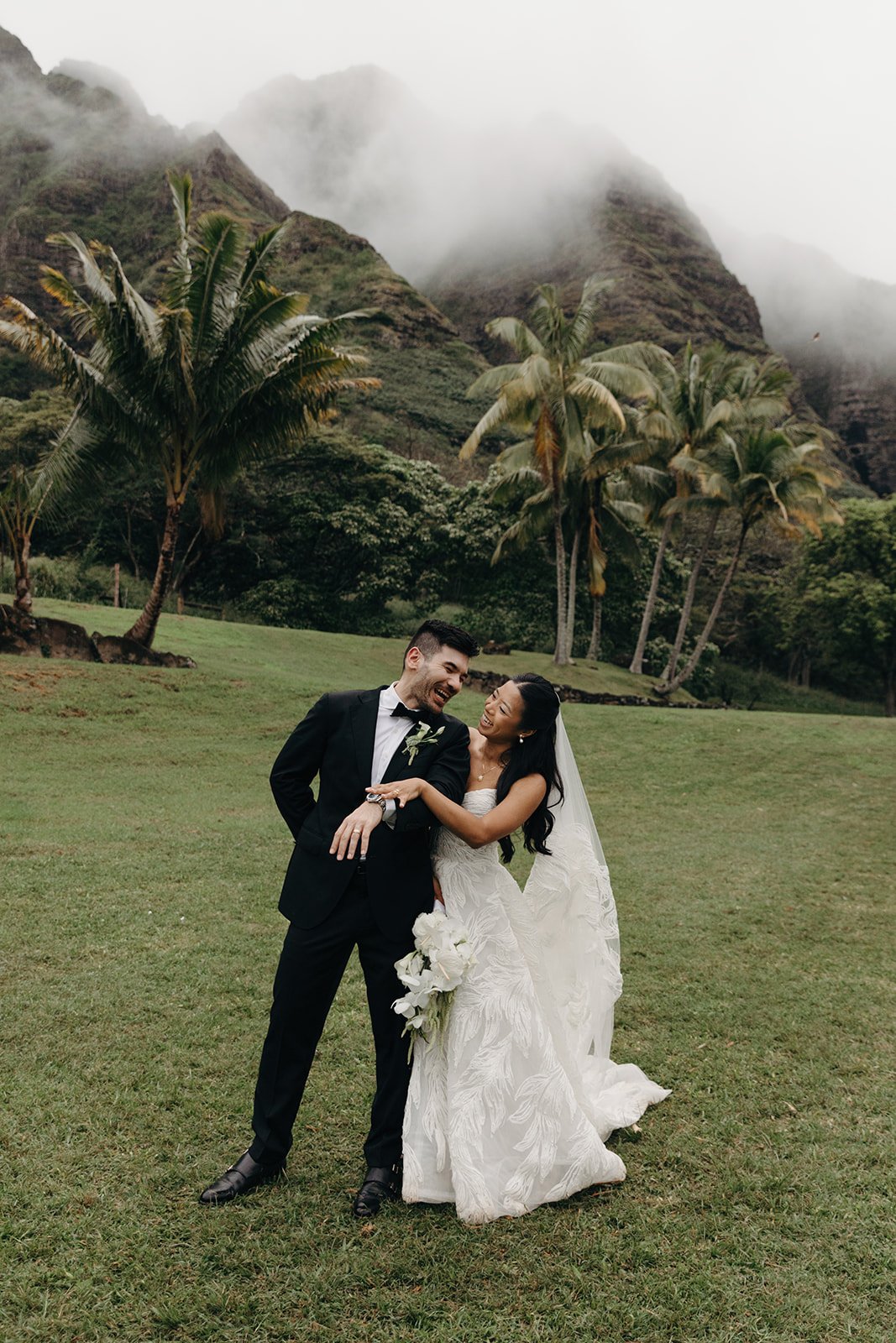 bride and groom in front of palm trees in hawaii