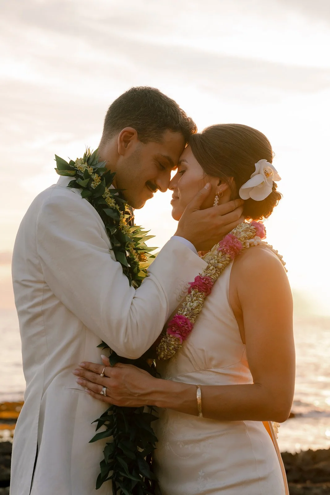 bride and groom watching sunset in hawaii
