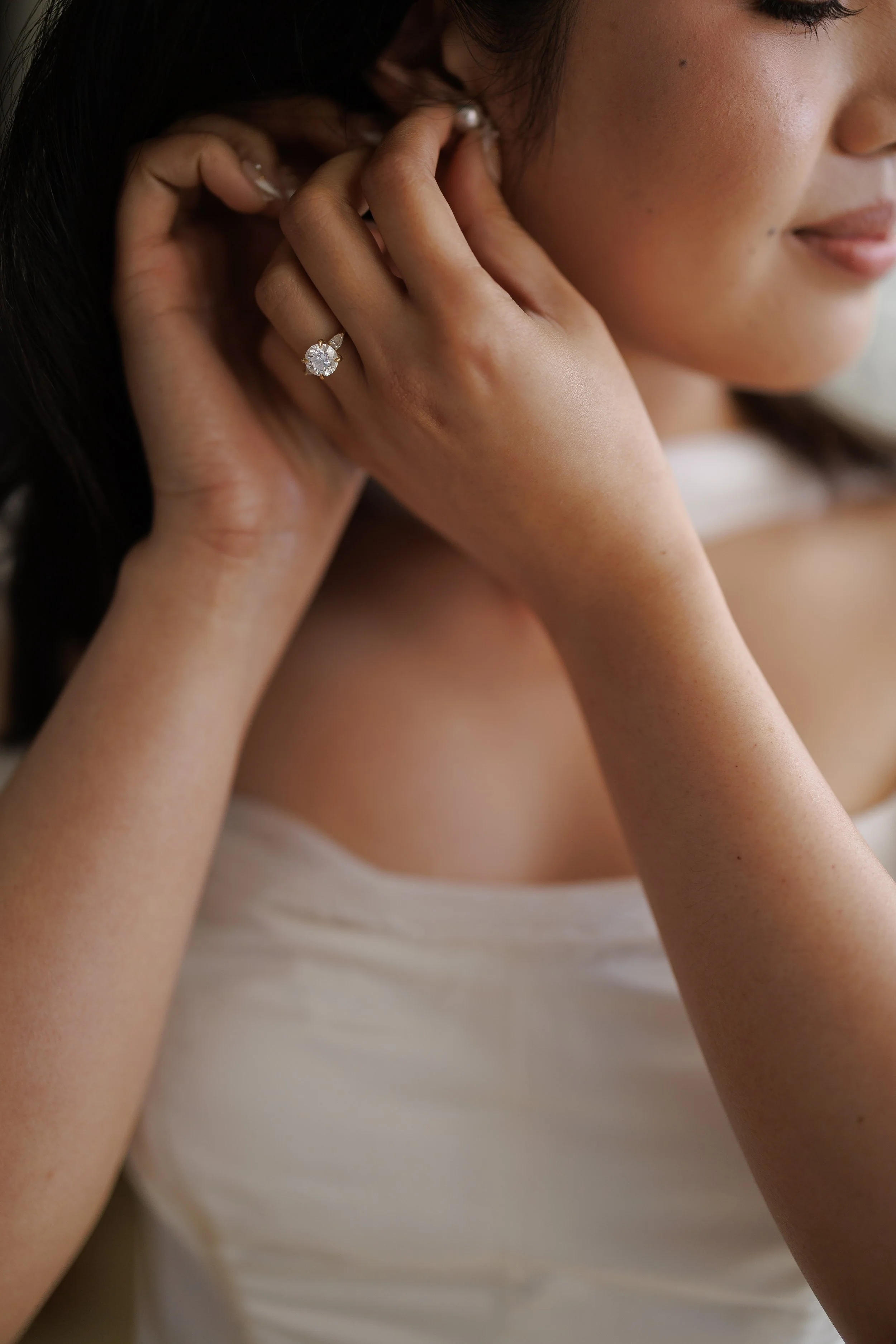 bride adjusts earing for getting ready photo