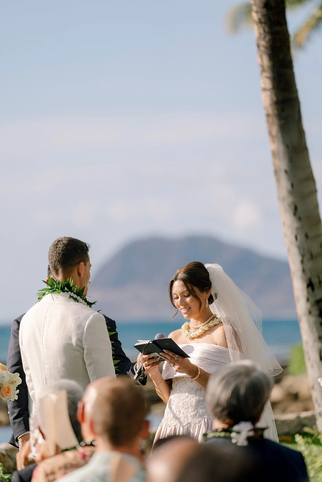 bride reading vows to groom by the ocean