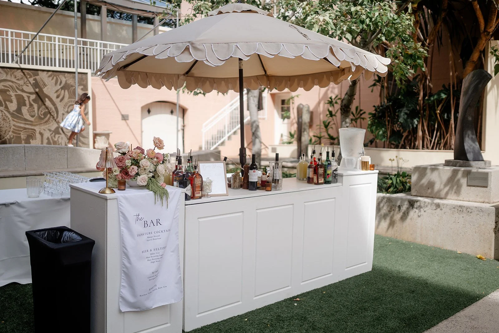 white bar with umbrella and mauve flowers