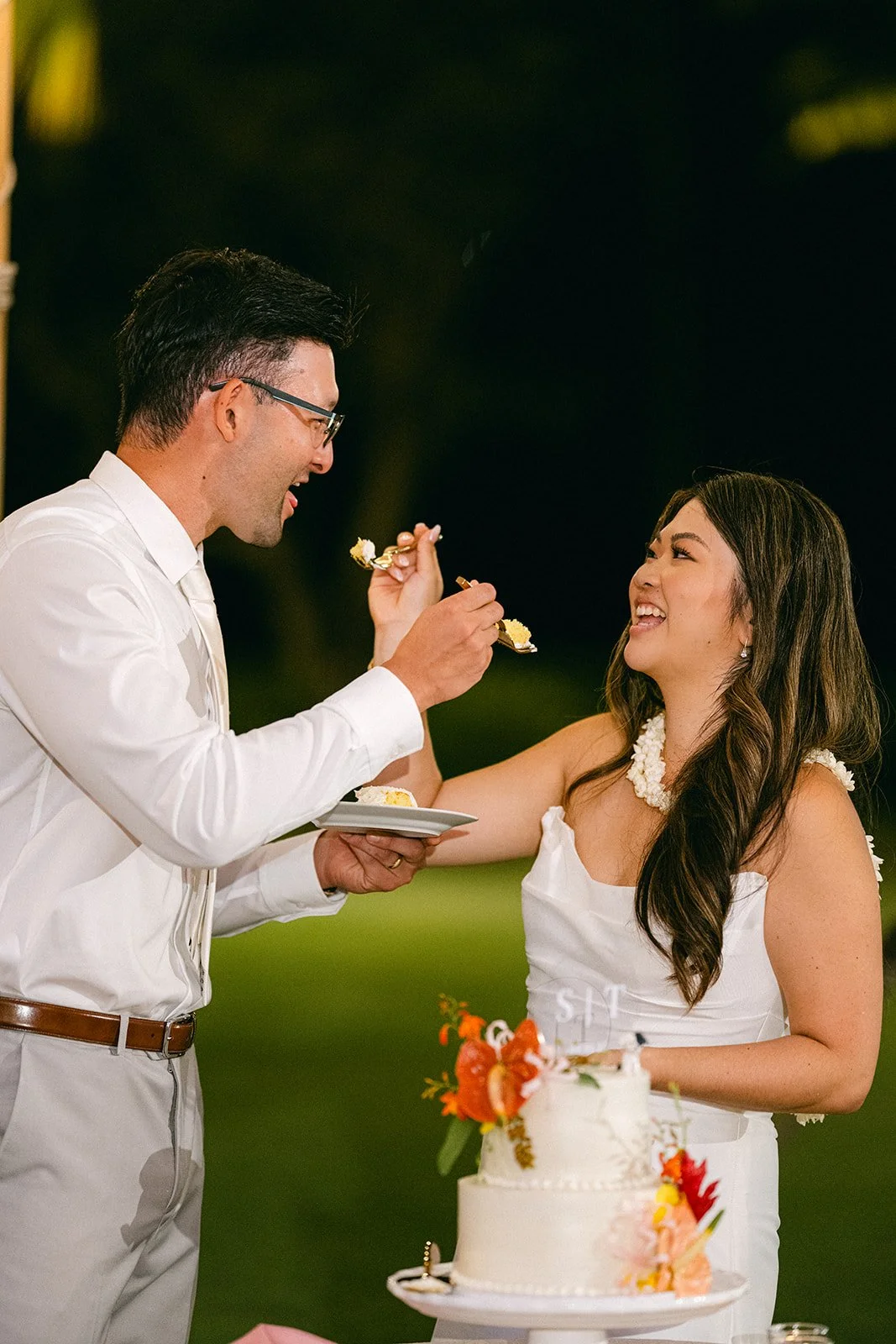 bride and groom cutting cake with tropical flowers